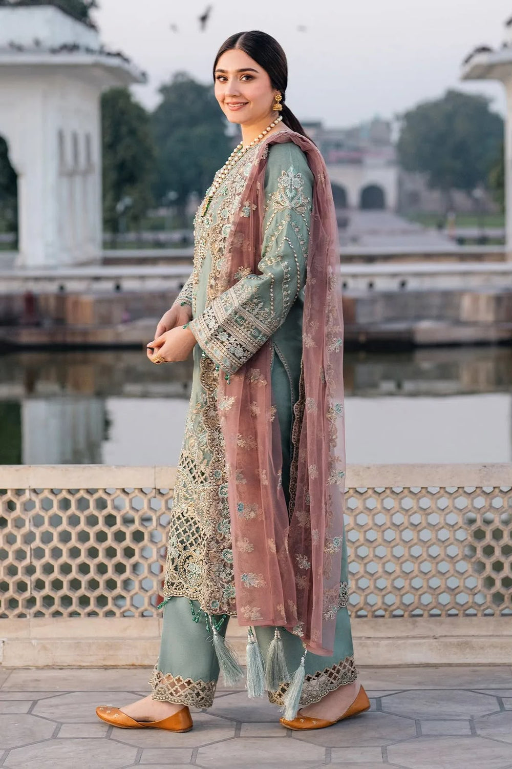 Dusty sage green embroidered chiffon suit side model view with mauve net dupatta

